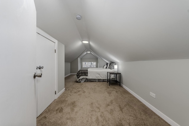 bedroom featuring carpet floors, baseboards, and vaulted ceiling