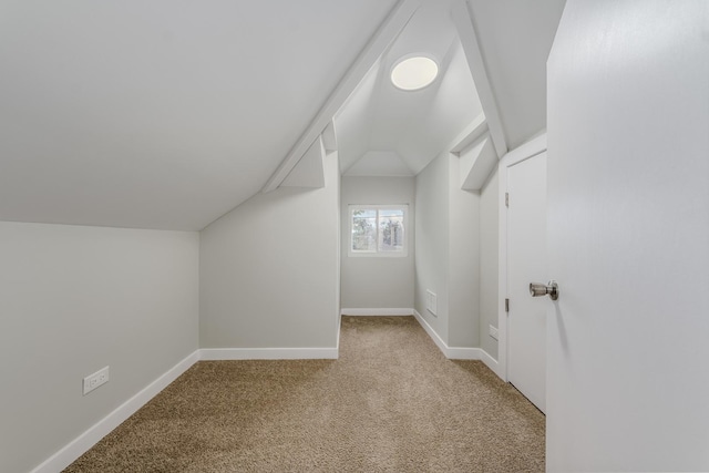 bonus room featuring baseboards, vaulted ceiling, and light colored carpet