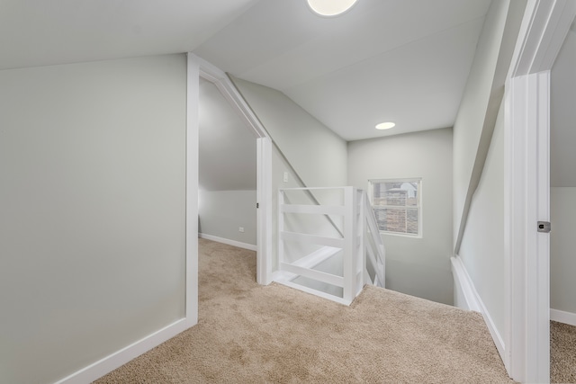 interior space with vaulted ceiling and light colored carpet