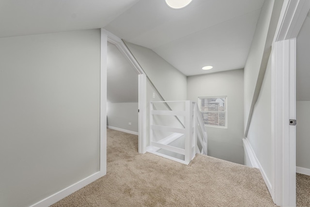 staircase with lofted ceiling, carpet flooring, and baseboards