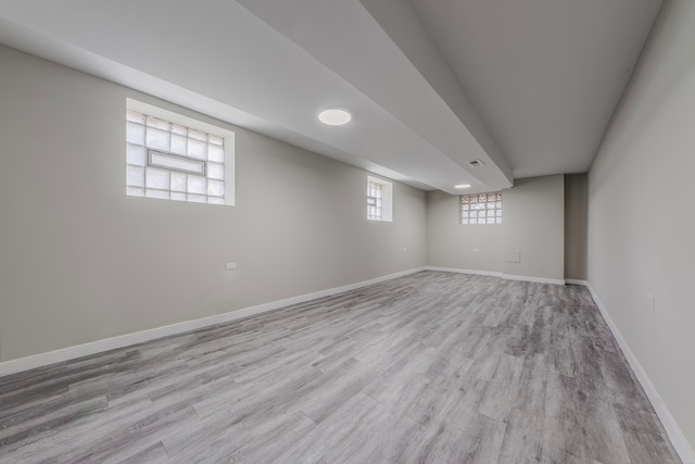 basement featuring plenty of natural light and light hardwood / wood-style floors