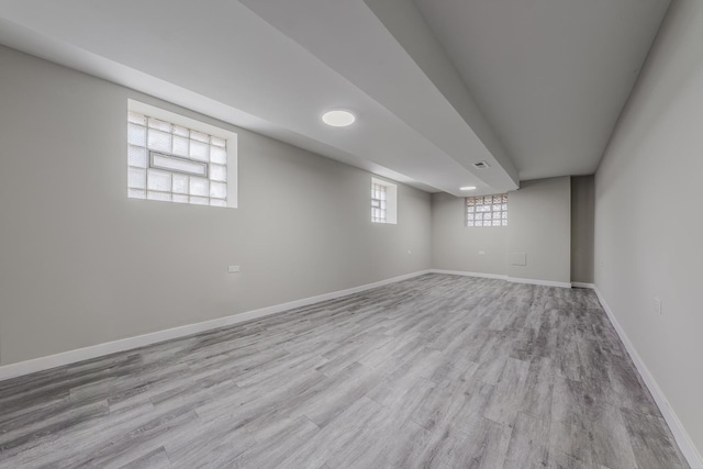 basement with baseboards and wood finished floors