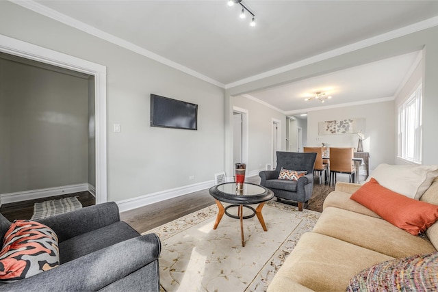 living area with ornamental molding, track lighting, baseboards, and wood finished floors