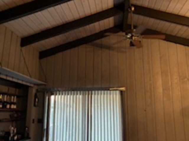 room details featuring wooden ceiling, beamed ceiling, wood walls, and ceiling fan