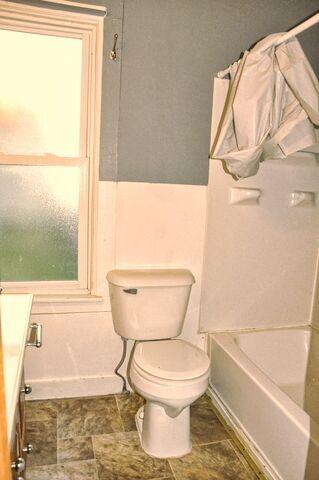 full bath with baseboards and toilet