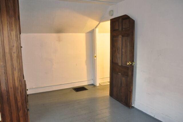 bonus room with vaulted ceiling, wood finished floors, and visible vents
