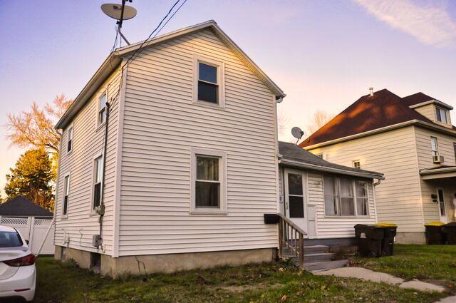 back of property at dusk with fence and entry steps