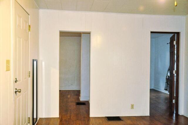 unfurnished room featuring dark wood-style flooring and visible vents