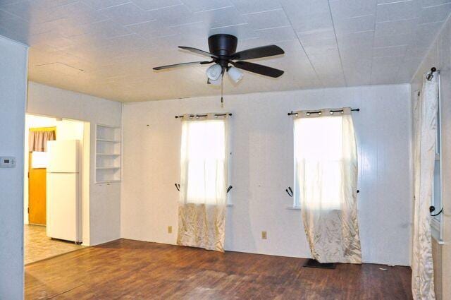 empty room with ceiling fan and wood finished floors