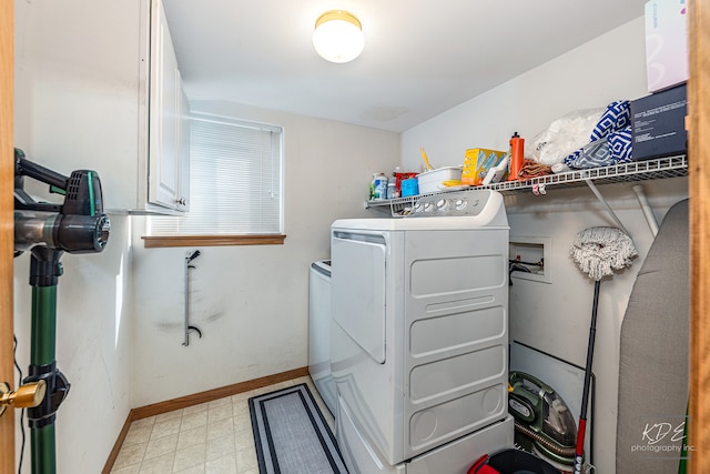 laundry area with washer and clothes dryer and cabinets