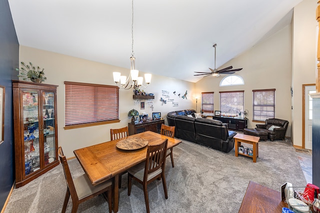 carpeted dining space featuring ceiling fan with notable chandelier and high vaulted ceiling