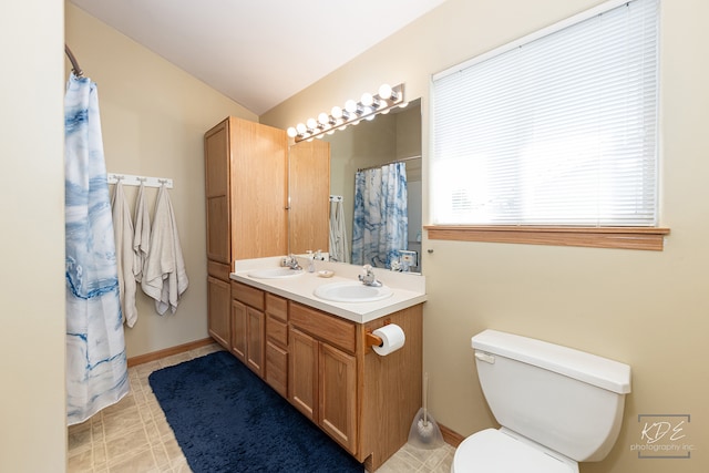 bathroom with lofted ceiling, vanity, and toilet