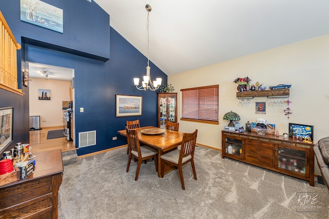 dining area with an inviting chandelier, carpet flooring, and high vaulted ceiling