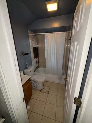 bathroom with tile patterned flooring, shower / bath combination with curtain, toilet, and vanity