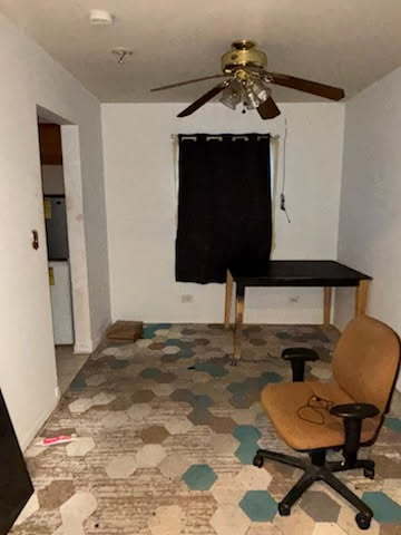 sitting room featuring a ceiling fan and carpet