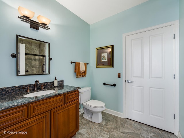 bathroom with a shower with door, vanity, and toilet