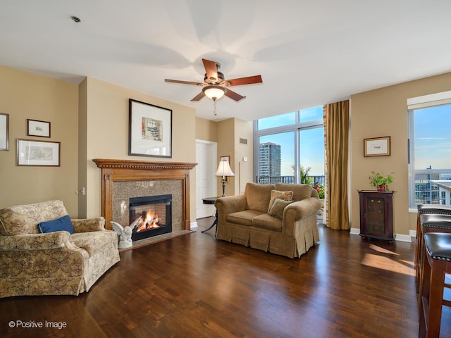 living room featuring a wealth of natural light, ceiling fan, a fireplace, and dark hardwood / wood-style flooring