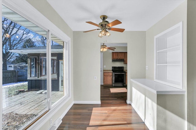 kitchen featuring stainless steel electric stove, a wealth of natural light, and dark hardwood / wood-style flooring