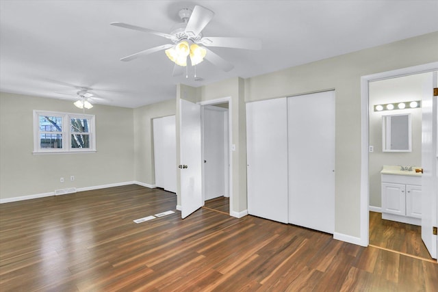 unfurnished bedroom featuring ensuite bathroom, ceiling fan, and dark hardwood / wood-style flooring