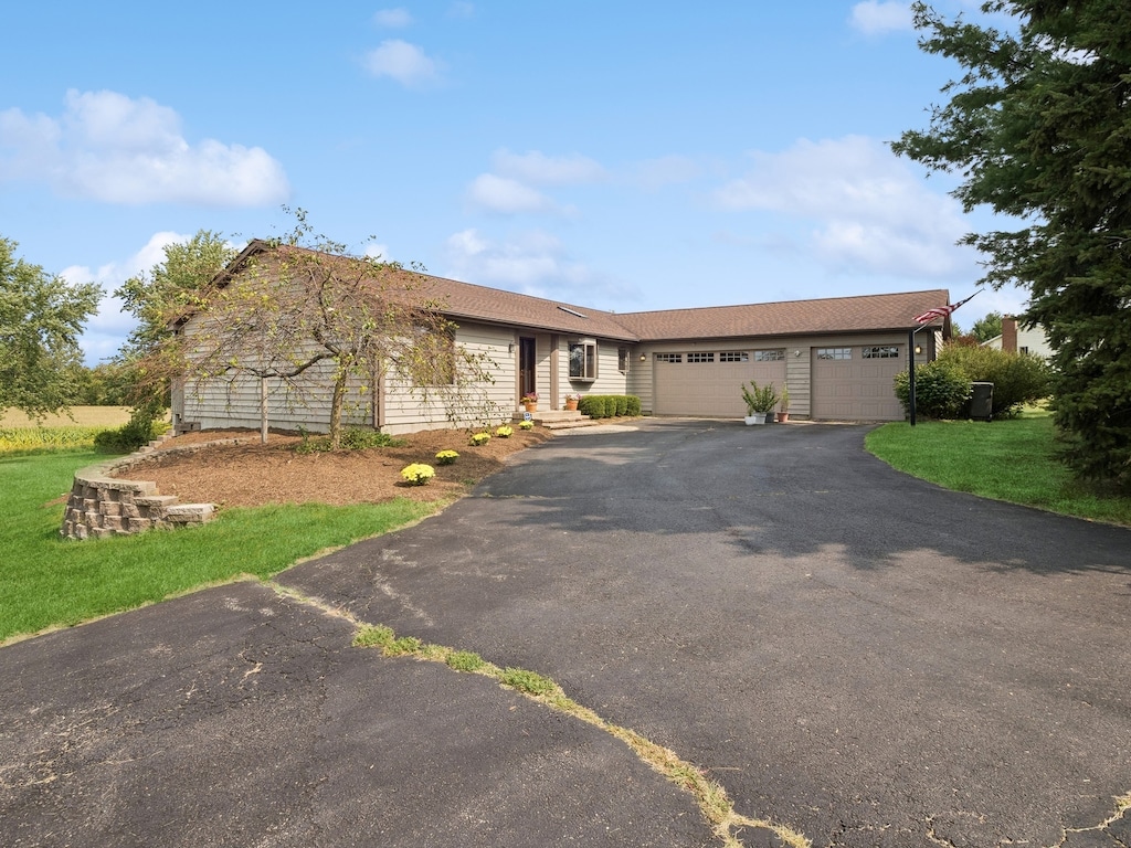 ranch-style home with a garage and a front yard