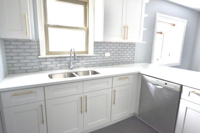 kitchen featuring a wealth of natural light, sink, white cabinets, decorative backsplash, and stainless steel dishwasher