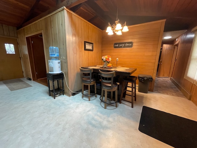 dining area with vaulted ceiling, wood ceiling, and wood walls