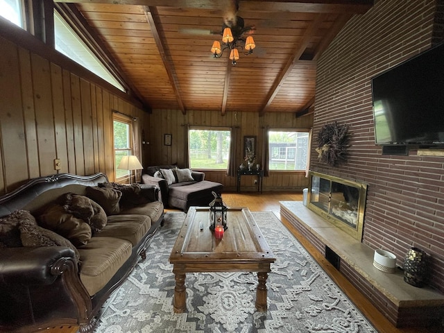 living room featuring a fireplace, wood-type flooring, lofted ceiling with beams, and wooden ceiling