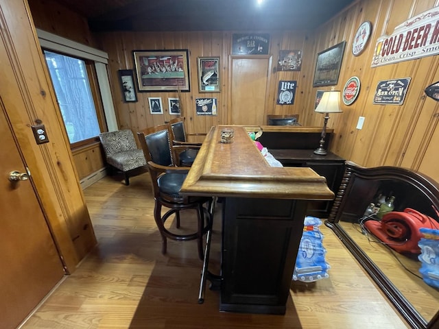 bar with wood walls and light wood-type flooring