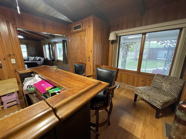 office area with wooden walls, dark wood-type flooring, and lofted ceiling