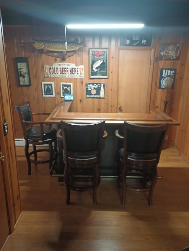 bar featuring wooden walls and hardwood / wood-style floors