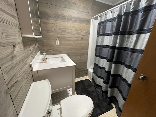 full bathroom featuring vanity, wooden walls, shower / bathtub combination with curtain, tile patterned flooring, and toilet