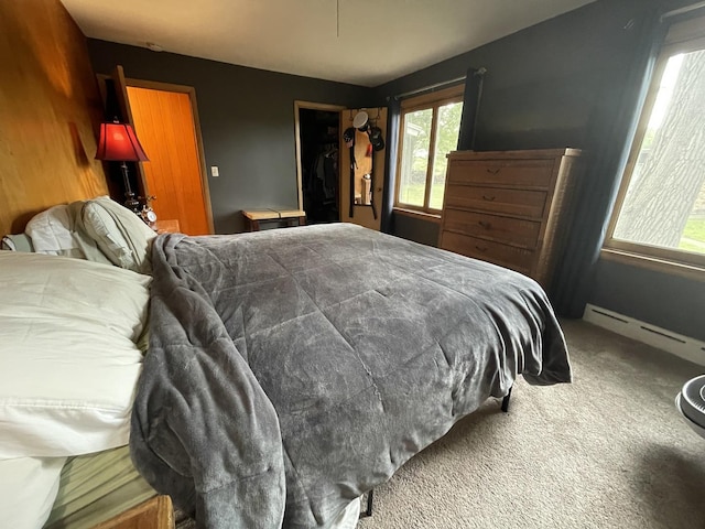 bedroom featuring carpet, a closet, and a baseboard heating unit