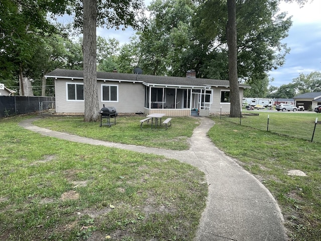 view of front of property featuring a sunroom and a front yard