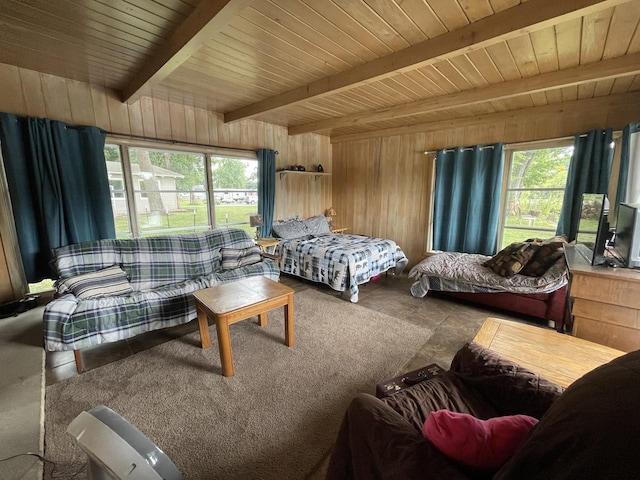 bedroom featuring beam ceiling and wooden walls