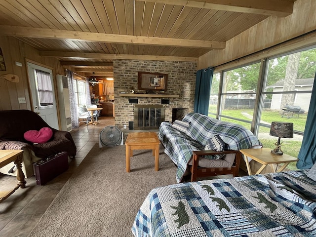 living room with wood walls, a healthy amount of sunlight, and beam ceiling