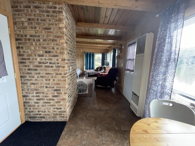 hallway featuring wood walls, dark tile patterned floors, beamed ceiling, and wood ceiling