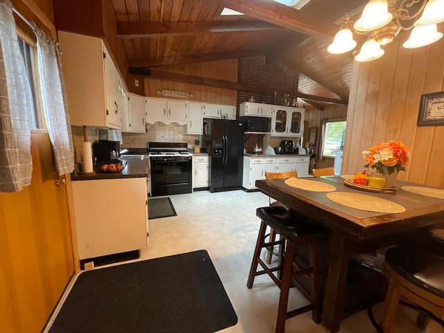 dining space with lofted ceiling with beams, wood walls, wood ceiling, and a chandelier