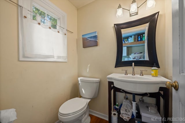 bathroom featuring toilet, wood-type flooring, and sink