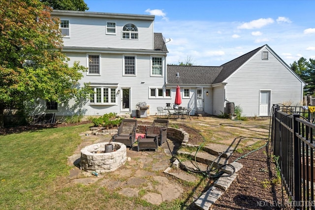 rear view of property with a lawn, a patio area, and an outdoor fire pit