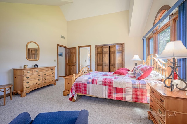 carpeted bedroom with a closet, visible vents, and high vaulted ceiling