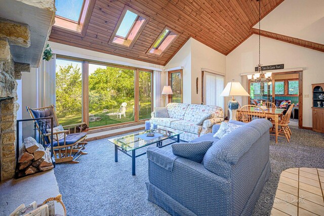 carpeted living room with wood ceiling, high vaulted ceiling, a skylight, and a notable chandelier