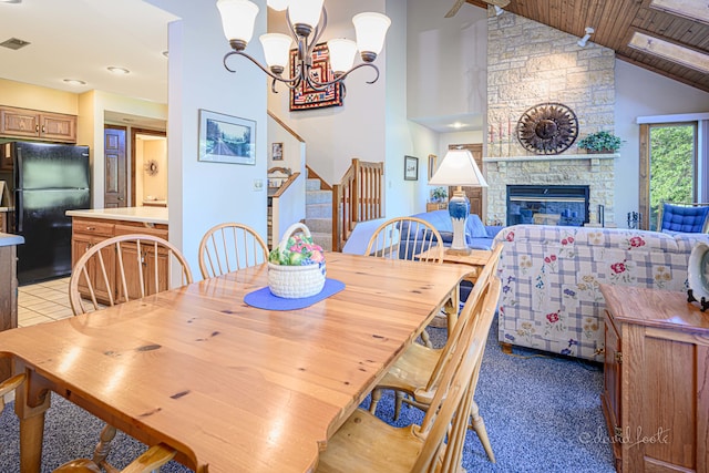 dining room featuring a fireplace, wood ceiling, light colored carpet, a notable chandelier, and high vaulted ceiling