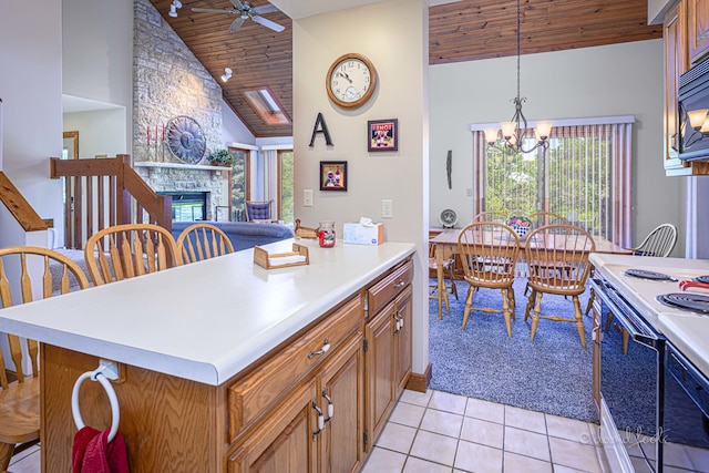 kitchen with ceiling fan with notable chandelier, decorative light fixtures, wooden ceiling, a stone fireplace, and white range with electric cooktop