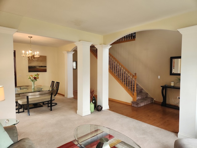 carpeted living room with ornate columns and an inviting chandelier