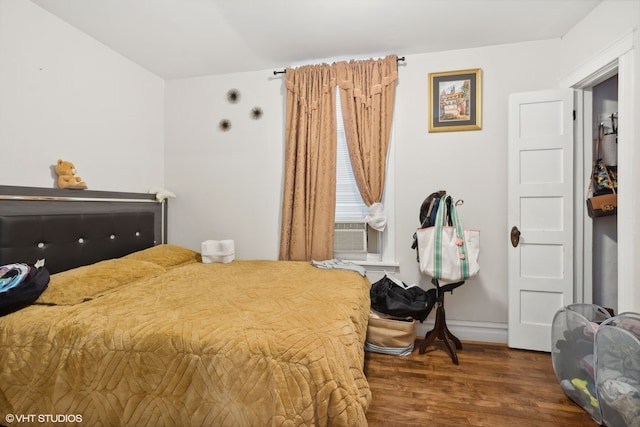 bedroom featuring cooling unit and dark hardwood / wood-style flooring