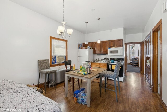 kitchen featuring dark wood-type flooring, white appliances, hanging light fixtures, and a chandelier