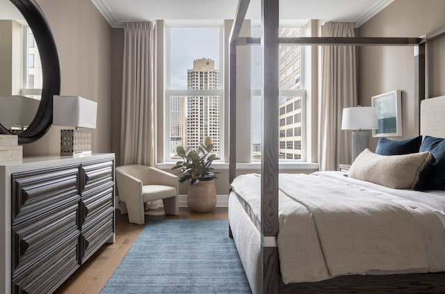 bedroom with hardwood / wood-style flooring and ornamental molding