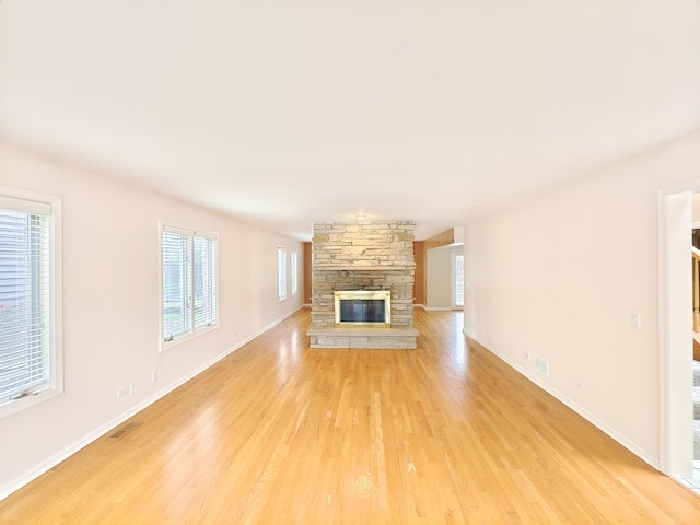 unfurnished living room with light wood-type flooring and a fireplace