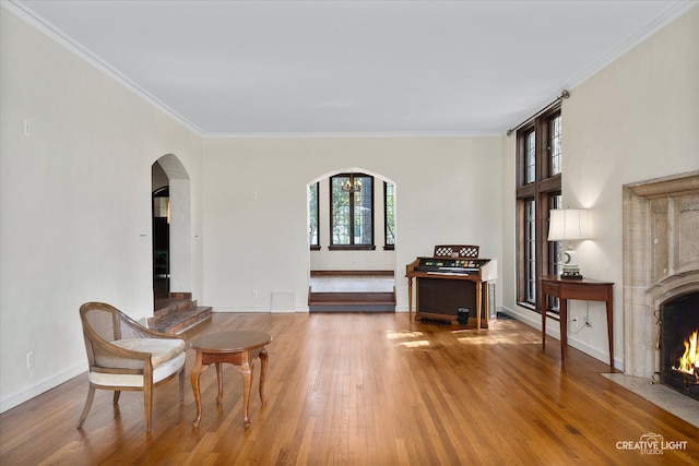 sitting room featuring a high end fireplace, hardwood / wood-style floors, and crown molding