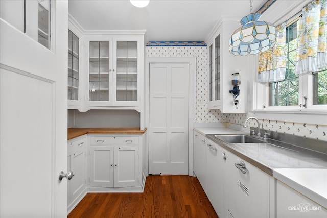 kitchen with pendant lighting, white cabinets, dark hardwood / wood-style floors, and sink